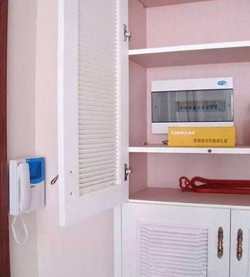 老電工把配電箱安裝在墻內(nèi)。曬太陽(yáng)太聰明了。